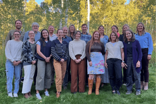Image of a group of people posing with aspen trees in background.