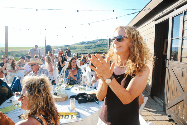 Photo of a person standing and clapping at an event.