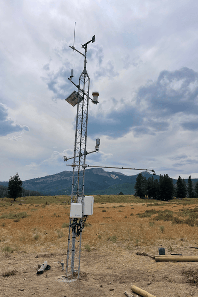 Image of a YBASIN station, a tall set of poles and measuring devices, in a field.