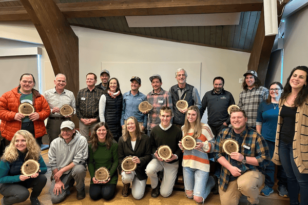 A group of people pose together holding up their Sustainability Awards.